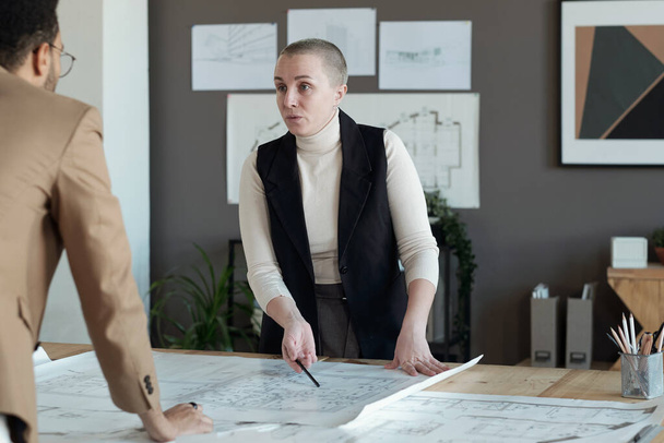 Confident mature female architect talking to male colleague - Photo, Image