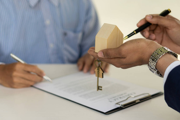 Real estate ideas, selling a house, or renting out real estate. The sales representative discusses the terms of the home sales contract for the customer to sign the legal contract document, - Foto, Imagen
