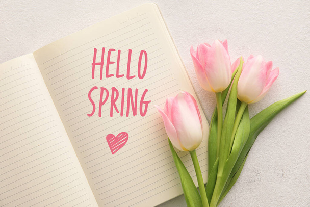 Zeszyt z tekstem HELLO SPRING i kwiaty tulipan na jasnym tle - Zdjęcie, obraz