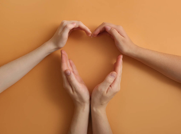 Human hands making heart on color background. Polyamory concept - Photo, Image