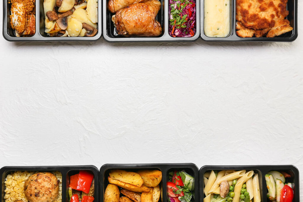 Cajas de almuerzo con diferentes comidas deliciosas sobre fondo claro - Foto, Imagen