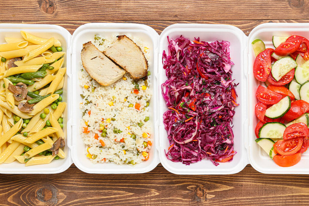 Boîtes à lunch avec différents délicieux aliments sur fond en bois, gros plan - Photo, image