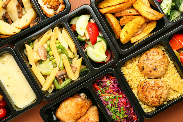 Lunch boxes with delicious meals on color background, closeup - Photo, Image