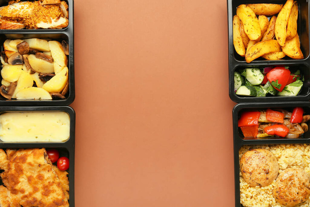 Обеденные коробки с вкусными блюдами на цветном фоне - Фото, изображение