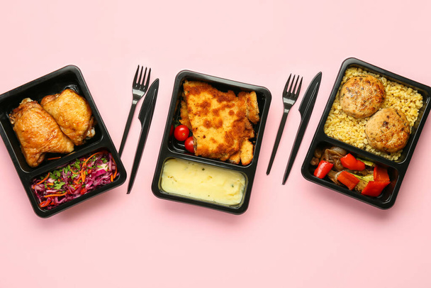 Lahodné jídlo v občerstvení boxy a příbory na barevném pozadí - Fotografie, Obrázek