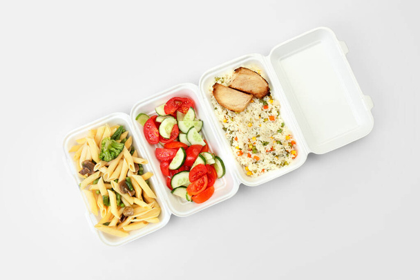 Різні смачні страви в обідніх коробках на світлому фоні
 - Фото, зображення