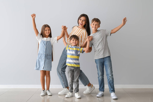 Happy dancing woman and her children on light background - Photo, Image