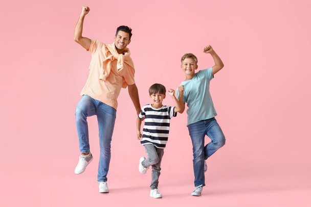 Щасливий танцюючий чоловік і його сини на кольоровому фоні
 - Фото, зображення