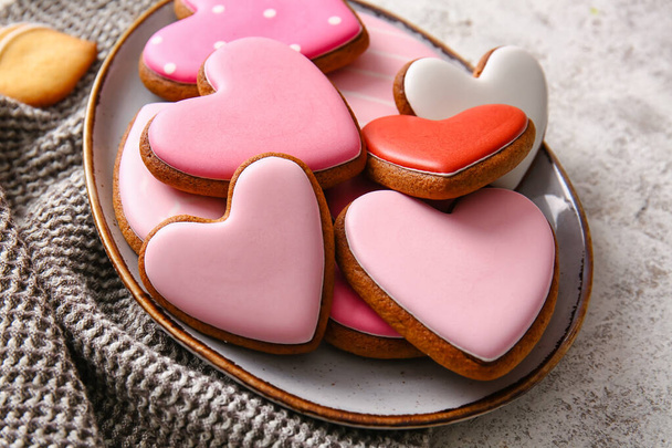 Plate with tasty heart shaped cookies on light background - Fotó, kép