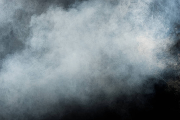 Dense Fluffy Puffs of White Smoke and Fog on Black Background, Abstract Smoke Clouds, Movement Blurred out of focus. Fumeurs soufflant de la machine mouche de glace sèche et flottant dans l'air, texture effet - Photo, image