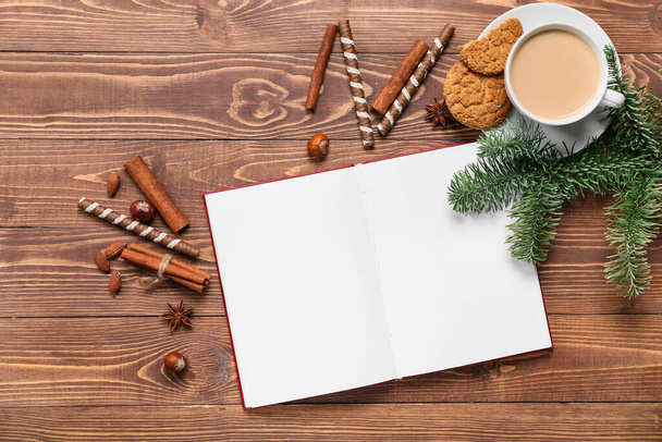 Opened book with blank pages, cup of coffee, cookies and winter decor on wooden background - Фото, изображение