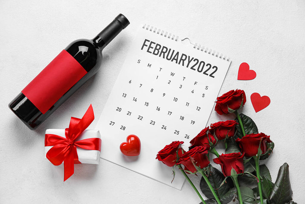 Kalender mit einer Flasche Wein, Geschenk, Herzen und Rosen auf weißem Hintergrund. Valentinstag-Feier - Foto, Bild