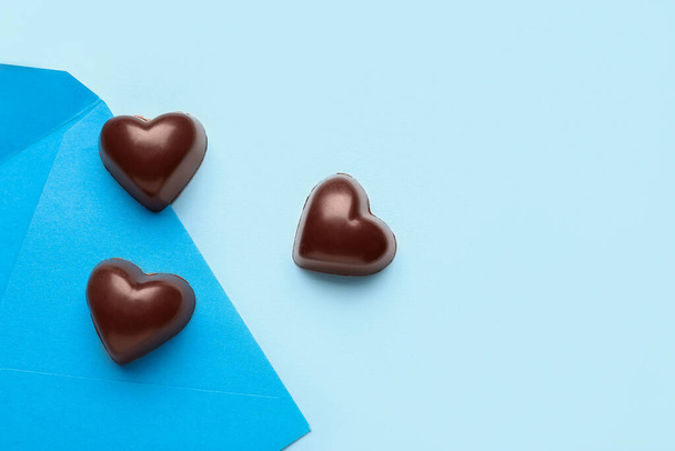 Вкусные конфеты в форме сердца на синем фоне - Фото, изображение