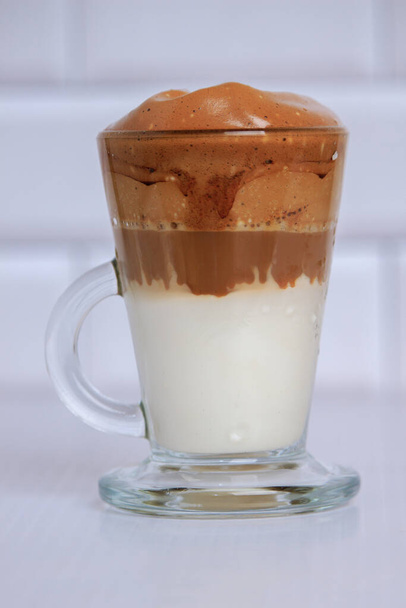 dalgona koffie in transparant kopje op wit tafelblad - close-up - Foto, afbeelding