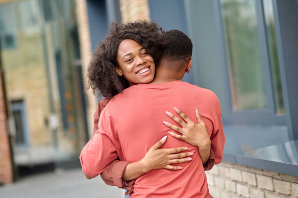 Woman hugging man standing with back to camera - Photo, image