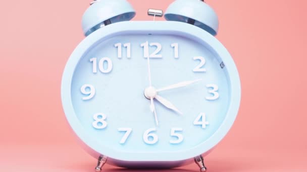 Čas vypršel Modrý budík ukazuje čas v 5 hodin. Čas dokončit práci na růžovém pozadí. - Záběry, video