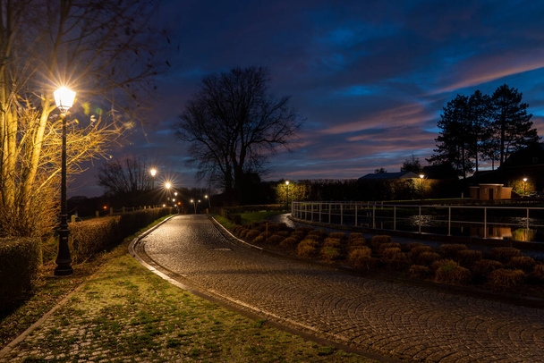 φωτισμός δρόμου σε λιθόστρωτο δρόμο κατά τη διάρκεια της χρυσής ώρας το πρωί - Φωτογραφία, εικόνα