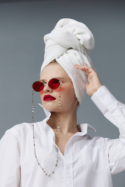 mujer glamorosa gafas de sol rojas cosméticos con toalla en la cabeza aislado fondo - Foto, imagen