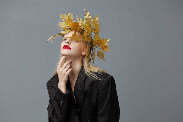 グラマラスな女性の黄金の葉の頭の上に黒ジャケットスタジオモデル変更なし - 写真・画像