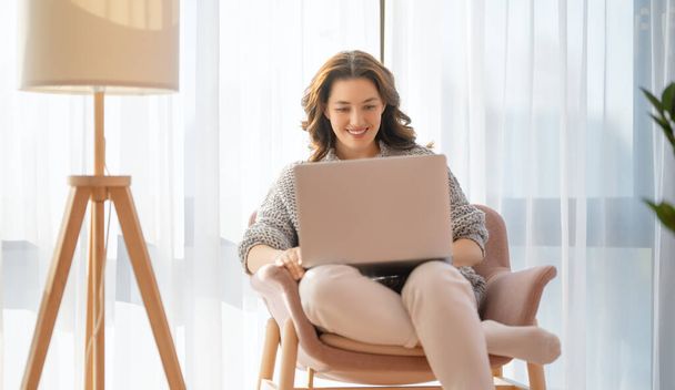 Happy casual beautiful woman using laptop at home. - Foto, Bild
