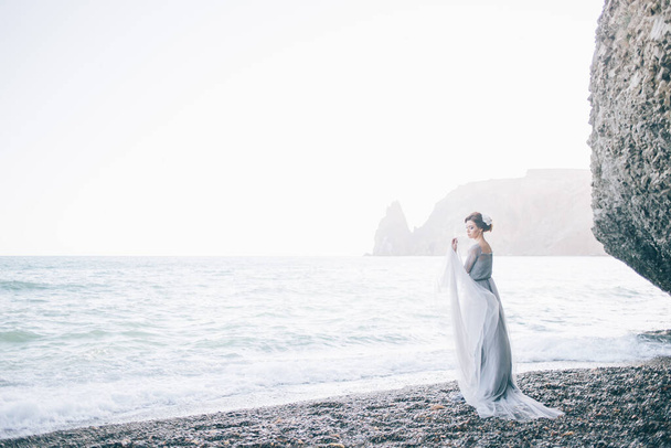 Beautiful bride on the beach is in a long dress - Foto, imagen