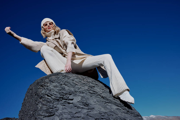 τουρίστας το φθινόπωρο ρούχα στέκεται σε ένα τοπίο βράχο γαλάζιο ουρανό τοπίο - Φωτογραφία, εικόνα
