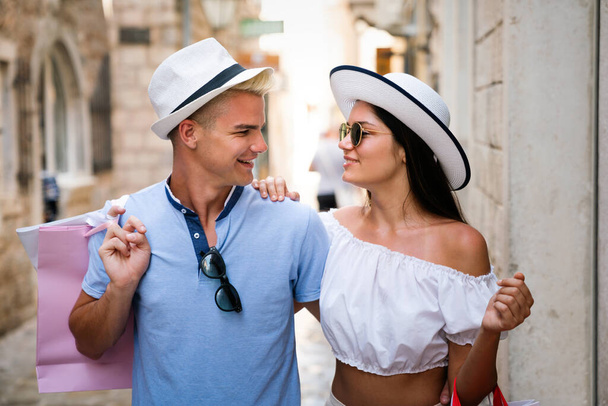We love shopping together. Beautiful young loving couple walking by the street on summer vacation - Fotoğraf, Görsel