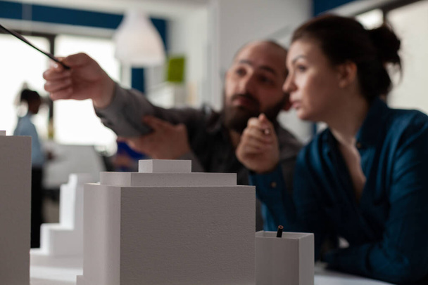 Szekrény fehér hab építészeti skála modell épületek előtt építészek csapat - Fotó, kép
