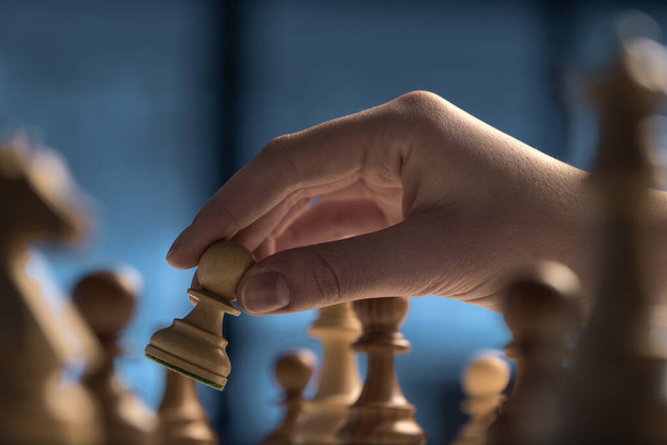 Professional player moving a pawn on the chessboard, strategy games concept - Foto, Imagen