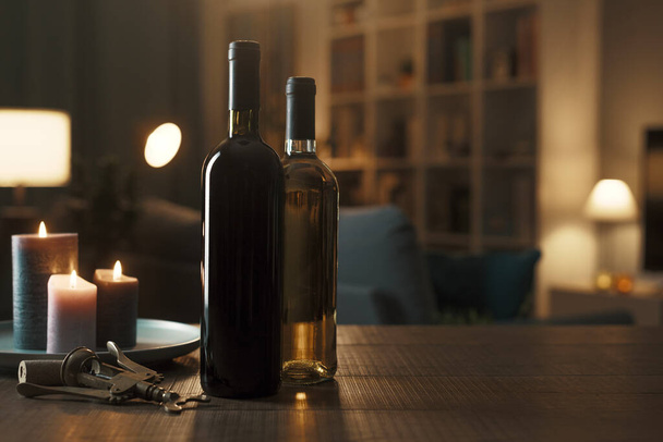 Luxury red and white wine bottles on a table in the living room at home, wine tasting concept - 写真・画像