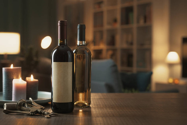 Luxury red and white wine bottles on a table in the living room at home, wine tasting concept - Foto, Imagem