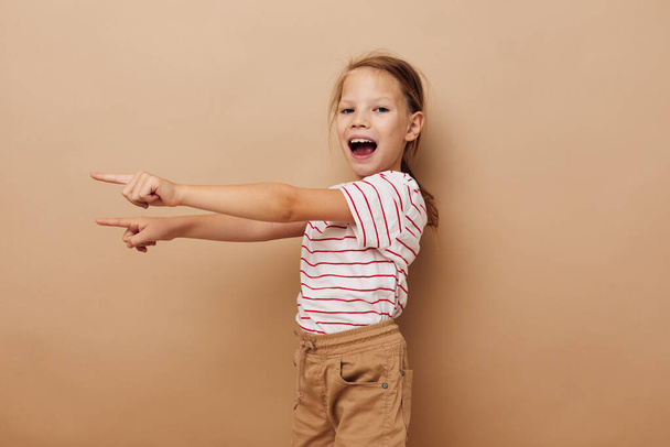 cheerful girl in a striped T-shirt gestures with her hands - Фото, изображение