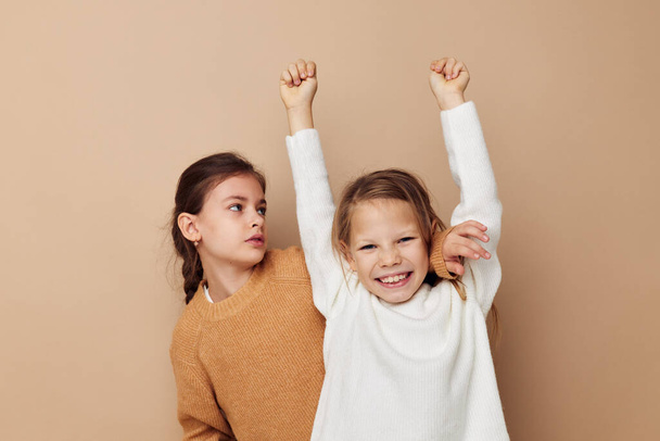 two cute little girls hug friendship lifestyle beige background - Foto, Imagem