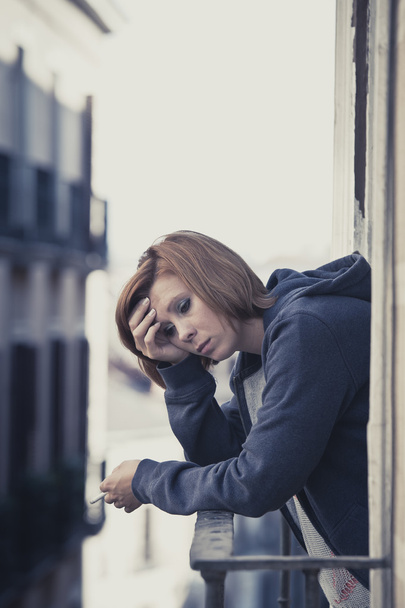 jonge vrouw te lijden aan depressie en stress buiten op het balkon - Foto, afbeelding