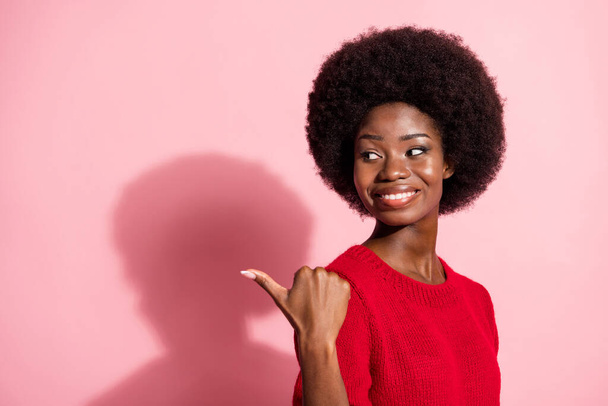Profile side photo of happy nice afro american woman look point thumb empty space sale isolated on pink color background - Фото, изображение