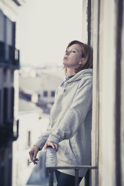 молодая женщина страдает депрессией и стрессом на открытом воздухе на балконе
 - Фото, изображение