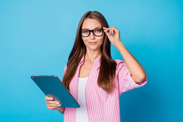Portrait of optimistic brunette lady hold tablet wear spectacles pink shirt isolated on vivid blue color background - Φωτογραφία, εικόνα