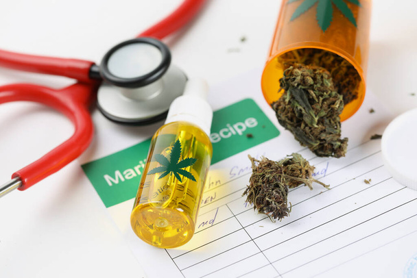 Jar with dried marijuana scattered on patient medical prescription - Foto, afbeelding
