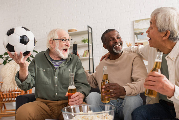 Positive interracial friends with beer and football spending time at home - Foto, Imagem