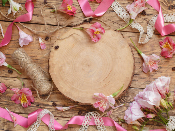 На дерев "яному столі лежали рожеві квіти й дерев" яна дошка з копіювальним простором. Гарні перуанські лілії мають простір для шаблонів. Романтичне свято. - Фото, зображення