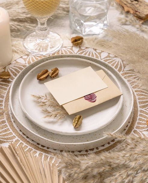 Yatay boş kartıyla bohem bir yer kaplayan düğün masası. Boho düğün kartı modeli. Kurumuş bitkiler, palmiye yaprakları ve otlarla tropik bej şablonu - Fotoğraf, Görsel