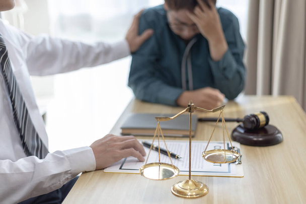 Prosecutor or lawyer comforts a client who is worried about a fraudulent business, Legal and Justice Litigation Assistance, legal consultant, scales of justice, law hammer, Litigation and justice. - Photo, Image