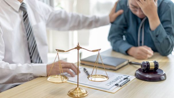Prosecutor or lawyer comforts a client who is worried about a fraudulent business, Legal and Justice Litigation Assistance, legal consultant, scales of justice, law hammer, Litigation and justice. - Photo, Image
