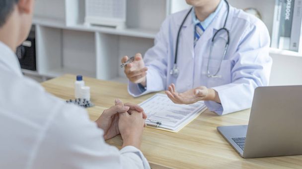 Male doctor made a diagnosis on a male patient and gave advice on treatment methods in the hospital examination room, Helping patients with medical advice, Health care counseling. - Foto, Bild