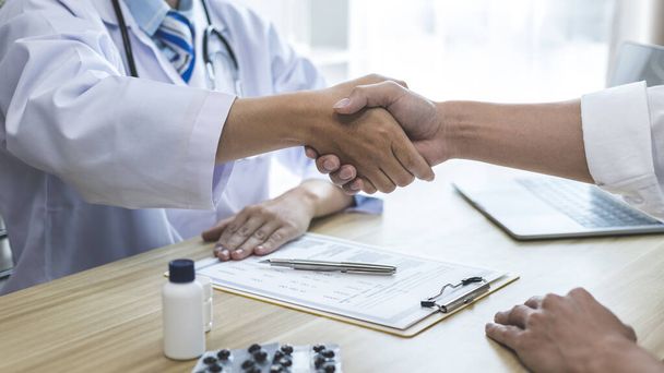 Doctor shake hands to congratulate the patient who came to treat the sick and recovered normally. Congratulations between doctor and patient, Medical treatment and health check. - Photo, Image