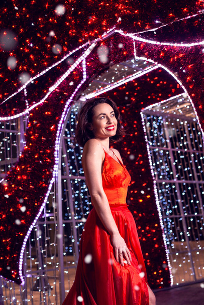 Hermosa mujer en vestido rojo en la decoración de Navidad. - Foto, Imagen