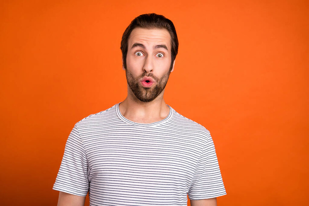 Photo of young man astonished bad fake information pouted lips isolated over orange color background - Foto, Imagem