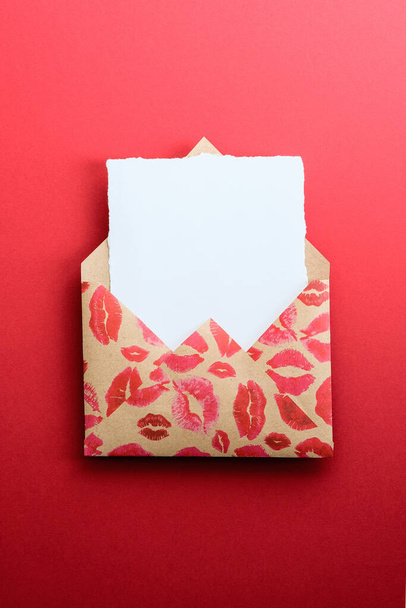 Love letter. White card mockup with craft paper envelope with lipstick marks print. Happy Valentine's Day concept. - Zdjęcie, obraz