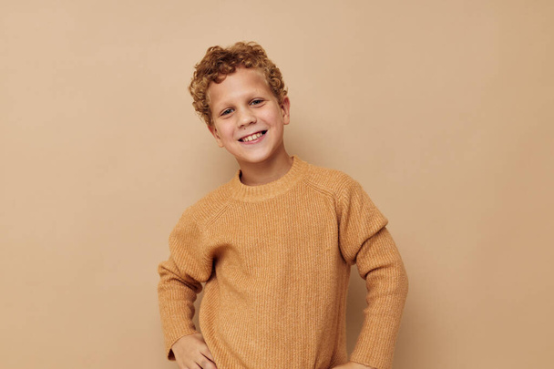 Photo of young boy in a beige sweater posing fun Lifestyle unaltered - Fotó, kép