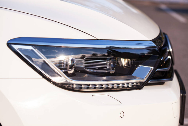 Modern LED headlight on a white car, close up. - Photo, Image